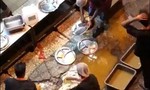 Nhân viên nhà hàng rửa đĩa trong vũng nước ngoài đường