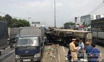 Sụp ổ gà, xe tải lật văng trúng xe khách ở Sài Gòn